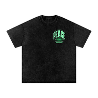 T-shirt oversized noir snow washed vu de face - petit écusson PEACE vert menthe sur la poitrine