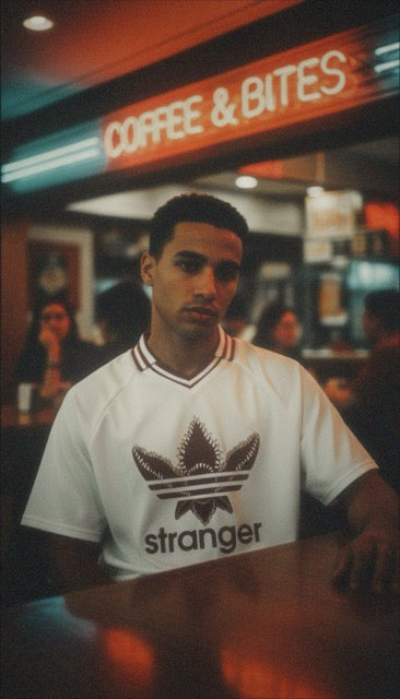 T-shirt oversized stranger porté devant une enseigne lumineuse - col V rouge et blanc