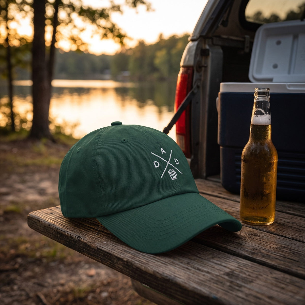Casquette baseball vert épicéa brodée du monogramme DAD blanc avec une chope de bière posée sur le hayon d'un pick-up au bord d'un lac au crépuscule à côté d'une bière fraîche - CHT'M Boutique