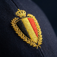 Macro de la broderie fil doré du blason belge sur la casquette Flexfit bleu marine