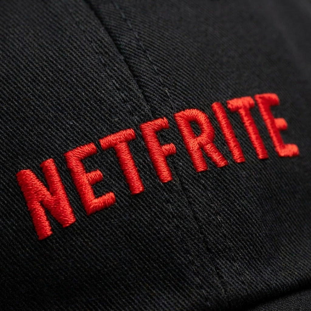 Macro de la broderie rouge NETFRITE sur le sergé de coton noir de la casquette
