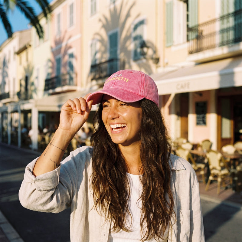 Casquette bronzette vintage rose portée par une femme en rue ensoleillée, ambiance riviera urbaine streetwear