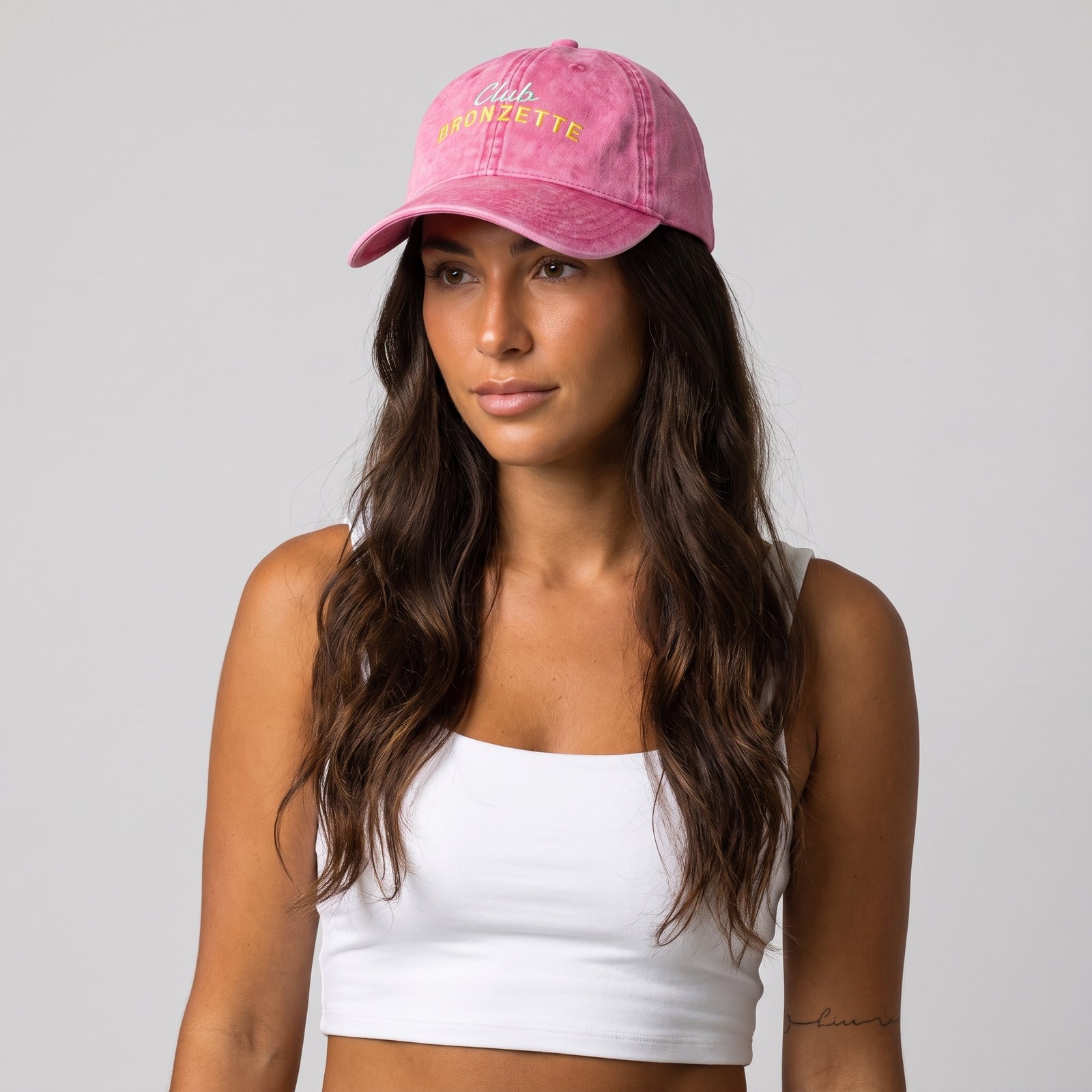 Casquette bronzette originale rose délavée portée par une femme, studio, broderie Club Bronzette vert menthe et jaune