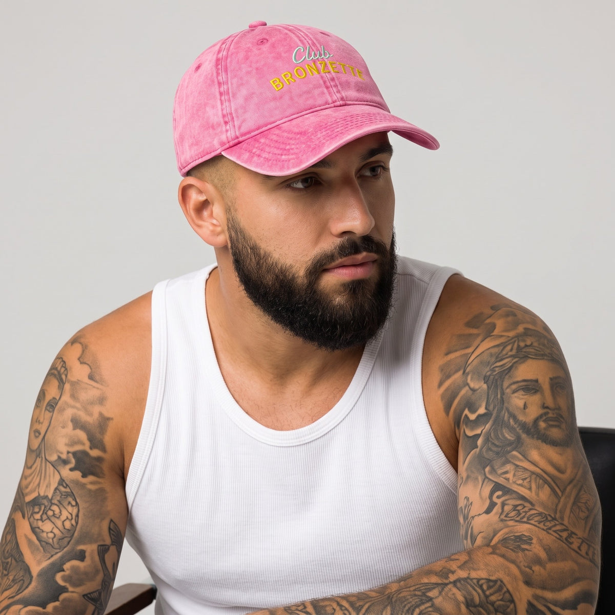 Casquette bronzette originale rose délavée portée par un homme barbu tatoué, studio fond neutre