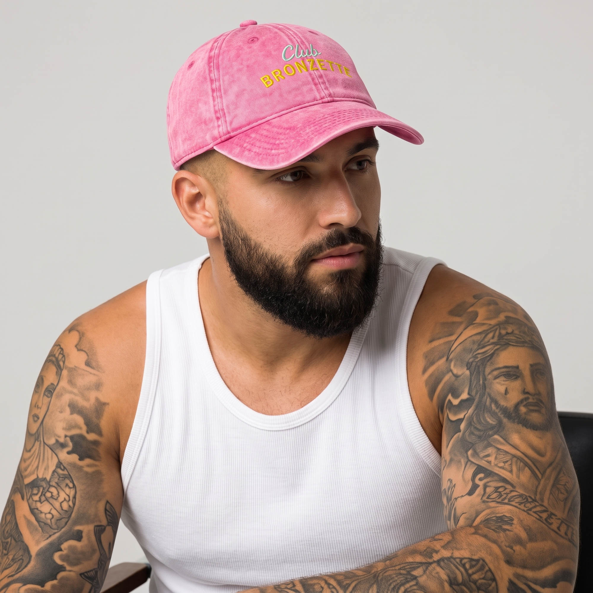 Casquette bronzette originale rose délavée portée par un homme barbu tatoué, studio fond neutre