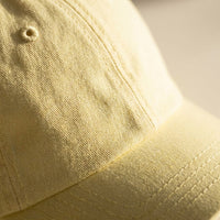 Macro du tissu coton et des surpiqûres de la casquette femme jaune pastel