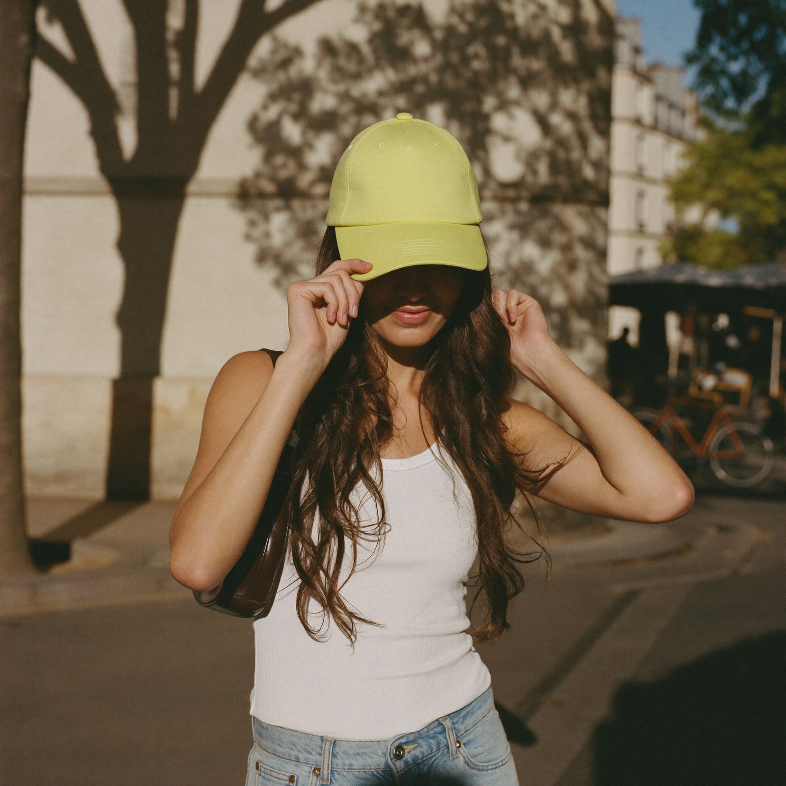 Casquette jaune pastel femme portée en look streetwear dans une rue parisienne