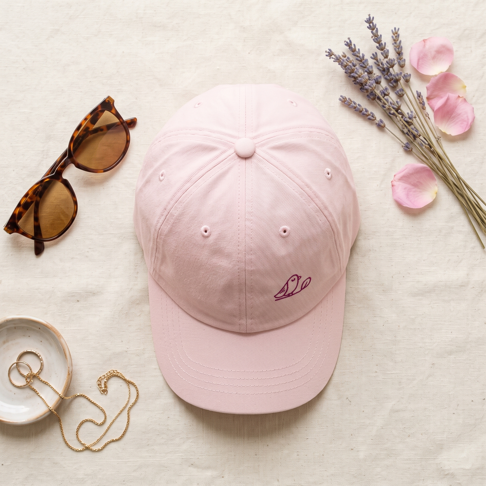 Casquette rose pastel femme en flatlay avec accessoires pastel