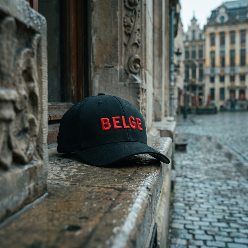 Casquette Flexfit noire brodée BELGE rouge posée sur le rebord en pierre d'une maison Art nouveau à Bruxelles sous la pluie - CHT'M Boutique