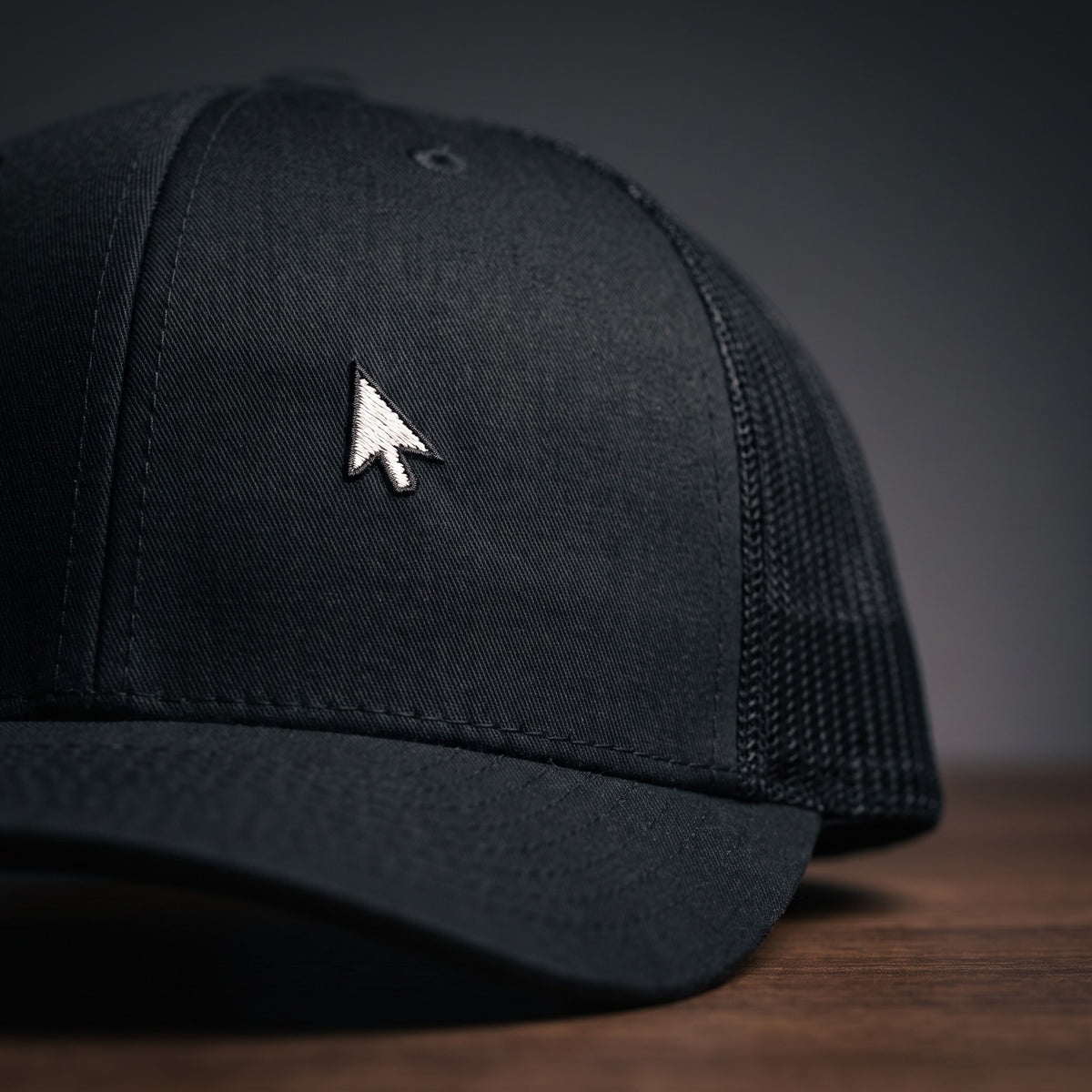 Détail du curseur de souris brodé sur casquette de geek trucker noire