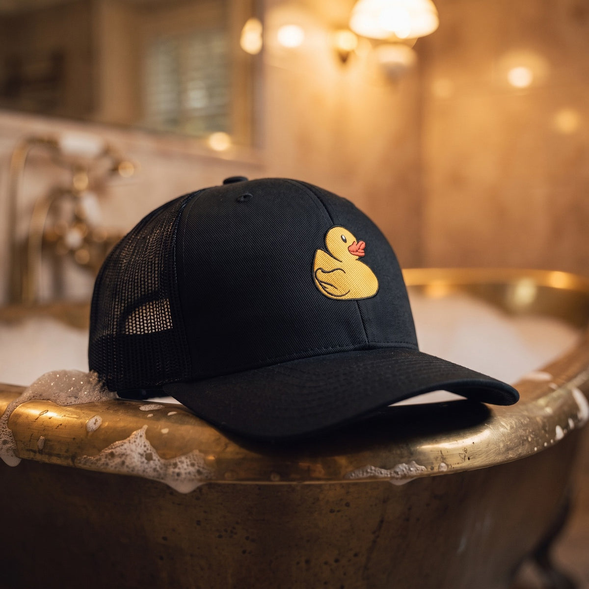 Casquette trucker noire brodée Petit Canard posée sur le bord d'une baignoire rétro avec de la mousse - CHT'M Boutique