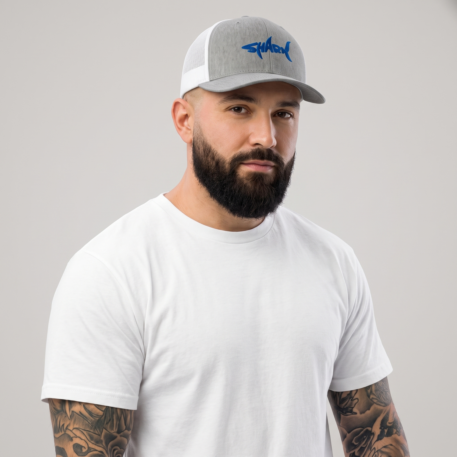 Homme portant la casquette requin SHARK brodée bleu roi, trucker gris chiné, photo studio