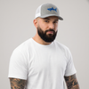 Homme portant la casquette requin SHARK brodée bleu roi, trucker gris chiné, photo studio