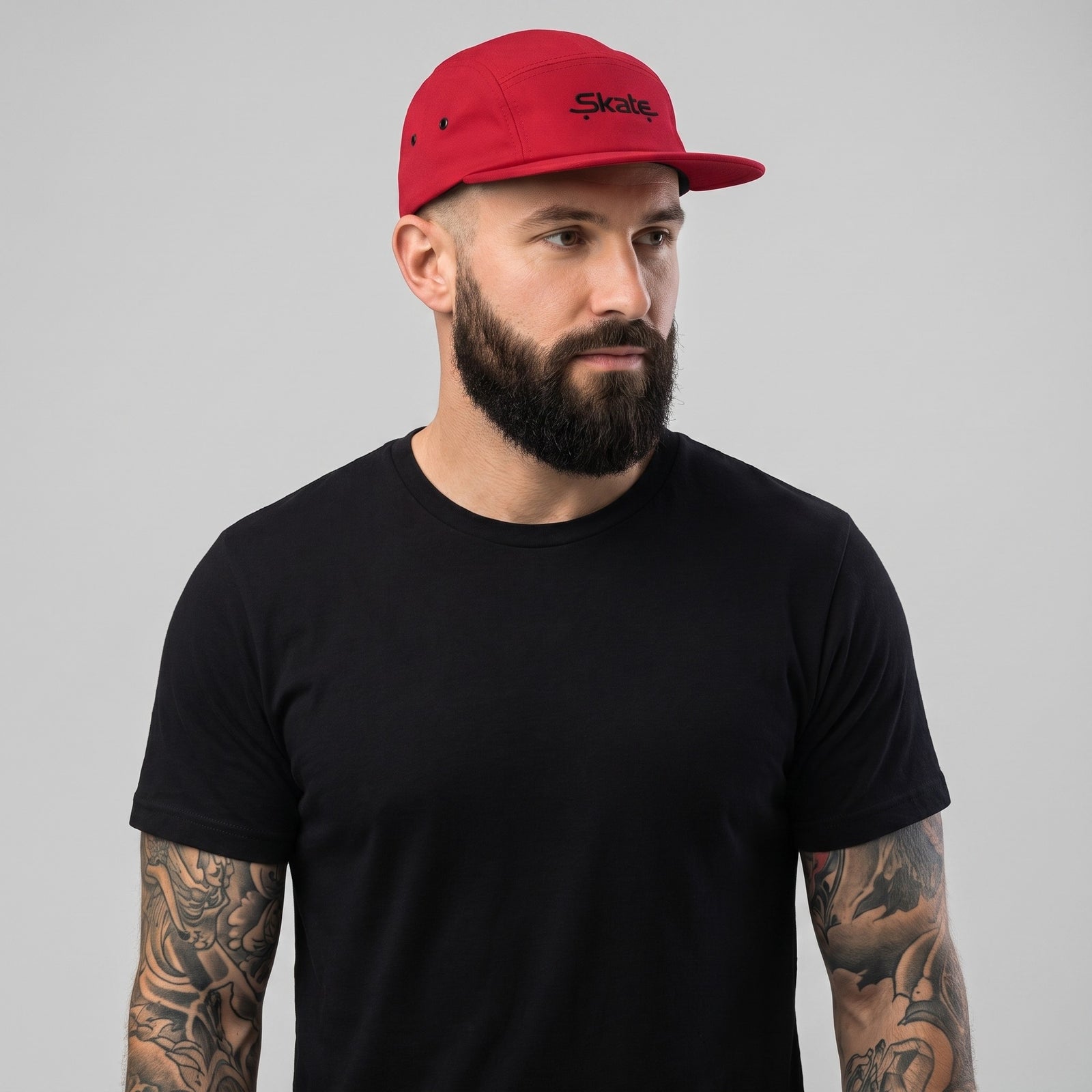 Homme portant la casquette skate 5 panneaux rouge originale, photo studio