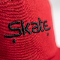 Macro de la broderie Skate noire sur le coton rouge de la casquette