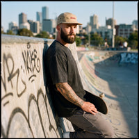 Casquette skate beige portée par un homme au skatepark, look streetwear urbain
