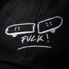 Macro de la broderie blanche skateboard cassé FVCK sur sergé de coton noir