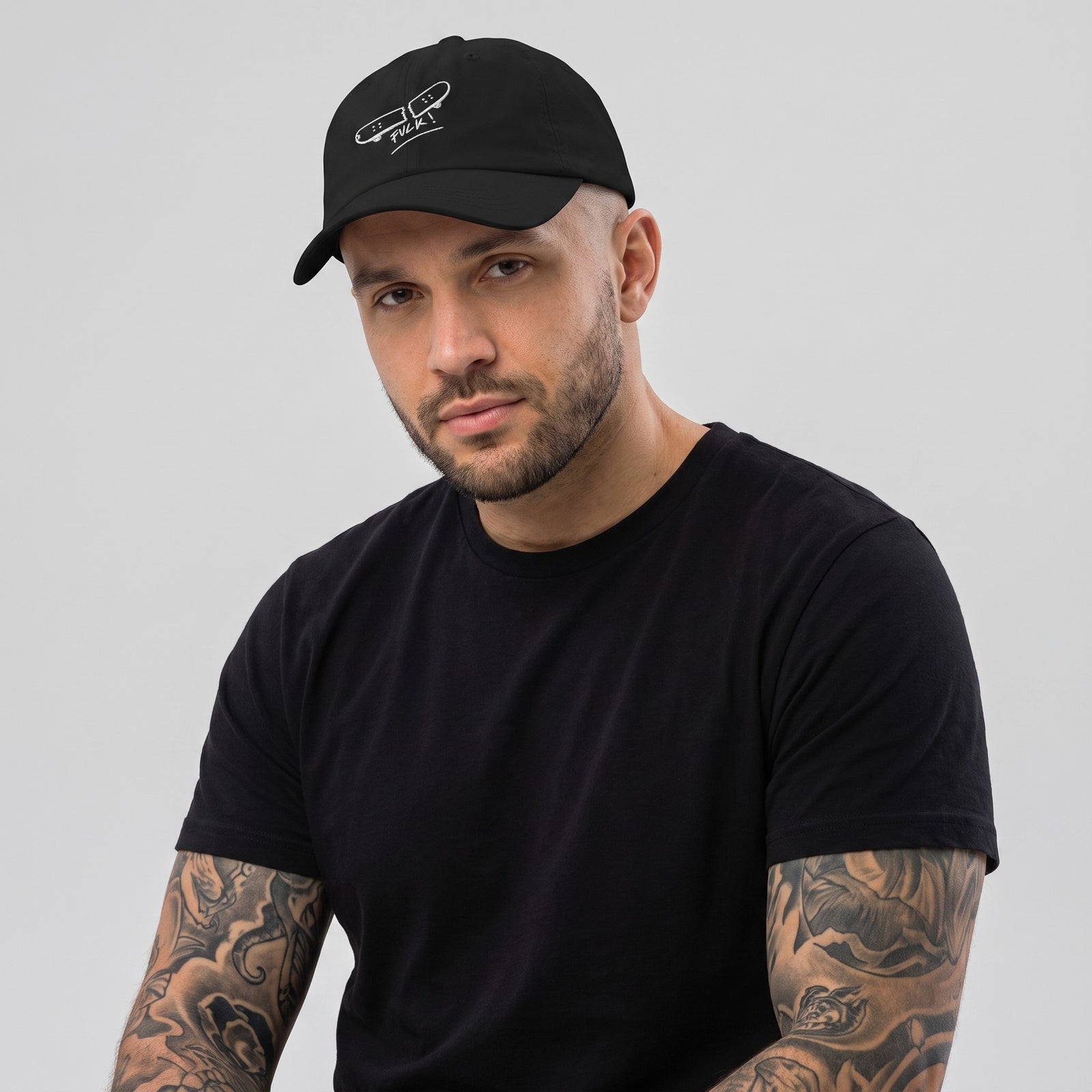 Homme portant la casquette skate brodée FVCK noire, dad hat streetwear à broderie skateboard cassé