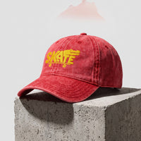 Casquette skate vintage rouge brodée crocodile vue trois quarts sur bloc de béton