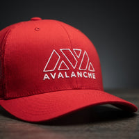 Gros plan sur le logo Avalanche brodé en blanc de la casquette trucker AVAX rouge