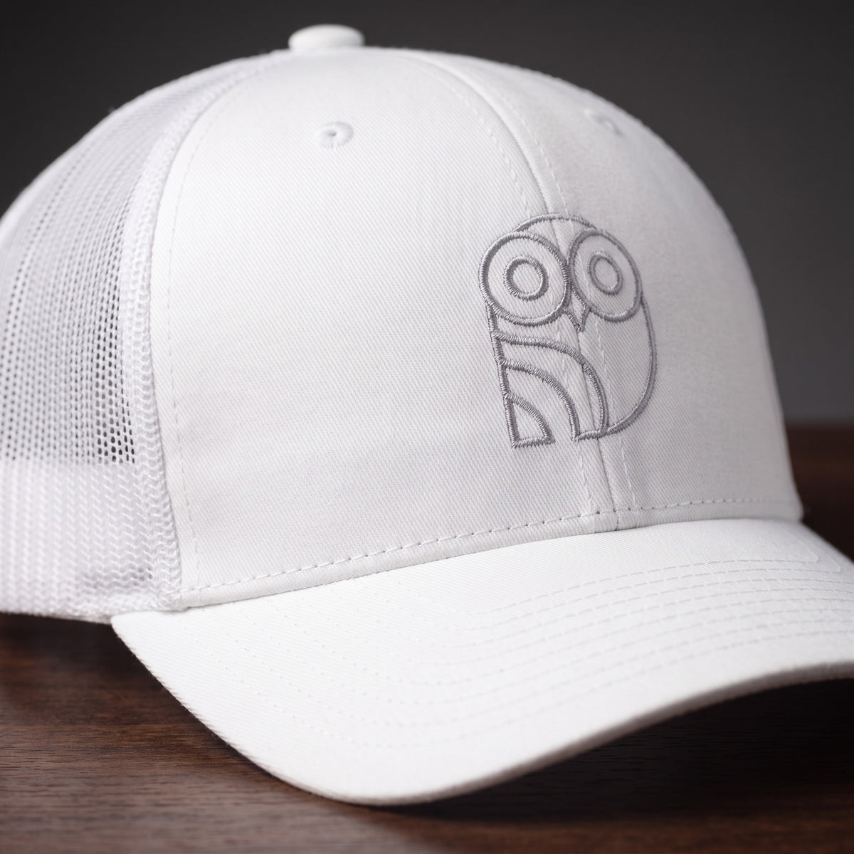 Gros plan sur le logo hibou brodé de la casquette trucker Coolawls