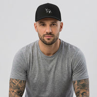 Homme portant la casquette trucker noire Coucou Petite Perruche de François Damiens, photo studio