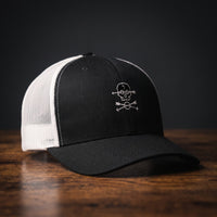 Casquette trucker brodée Crâne Boho noire et blanche - logo tête de mort et flèches croisées