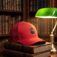 Casquette trucker CRAZY OWL posée dans une bibliothèque vintage cosy, ambiance chaleureuse