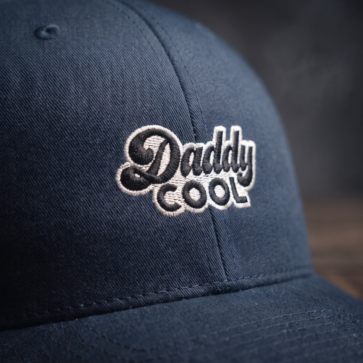 Détail du logo Daddy Cool brodé en relief sur casquette trucker bleu marine