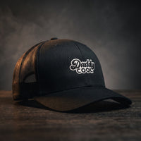 Casquette trucker Daddy Cool noire, logo brodé, posée sur bois sombre