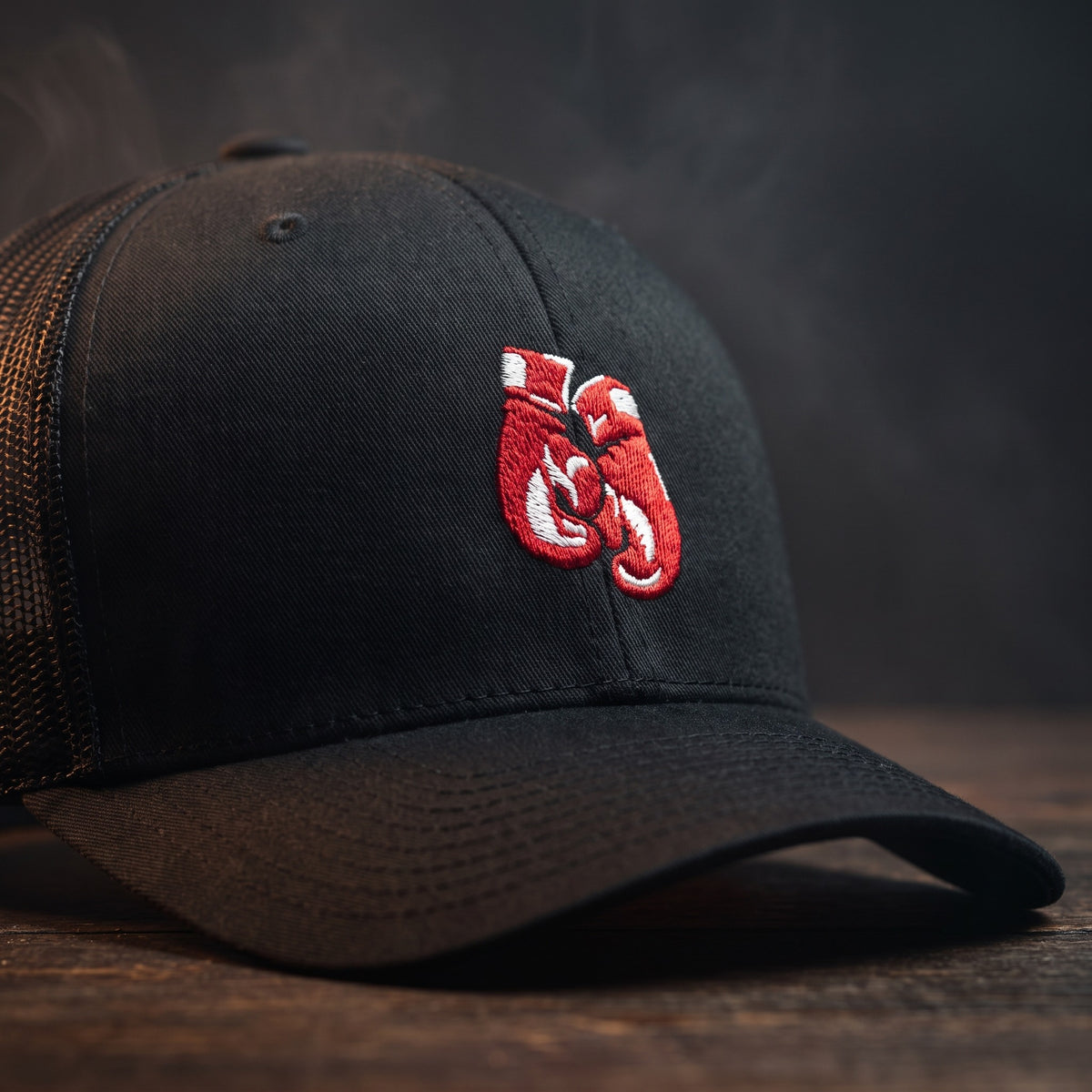 Gros plan sur la broderie en relief des gants de boxe rouges sur une casquette trucker noire