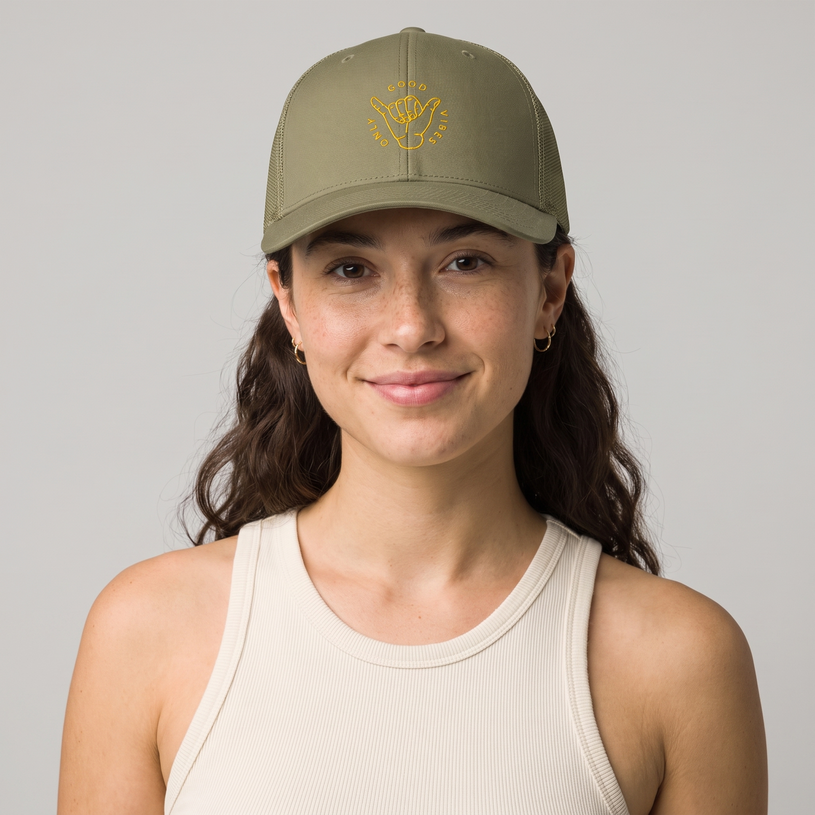 Femme portant la casquette trucker Good Vibes Only vert loden brodée shaka, photo studio