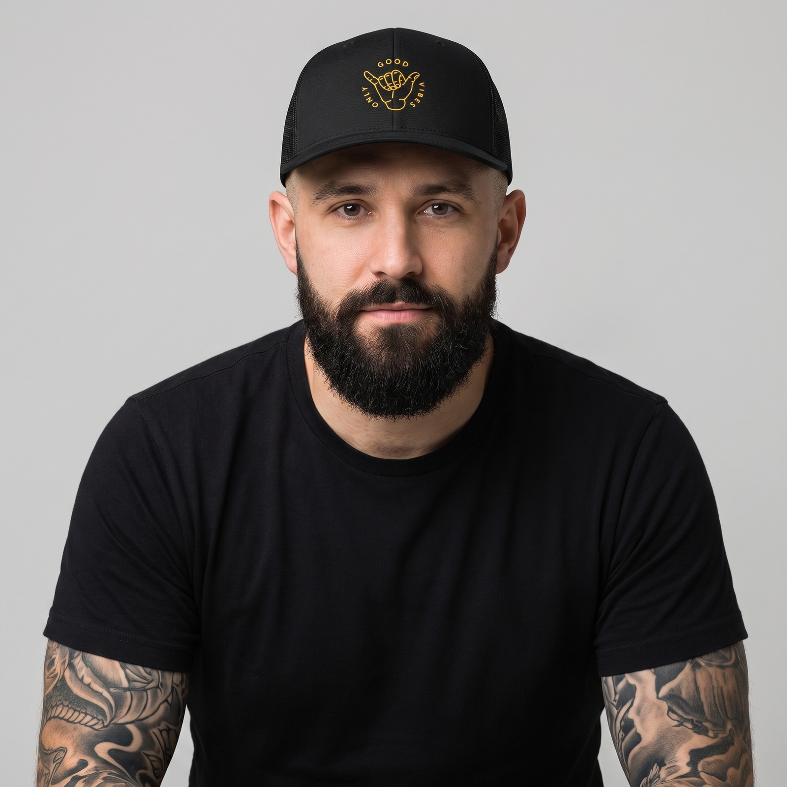 Homme portant la casquette trucker originale Good Vibes Only noire à broderie shaka dorée, photo studio