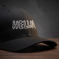 Détail de la broderie Hello! en relief sur casquette trucker noire