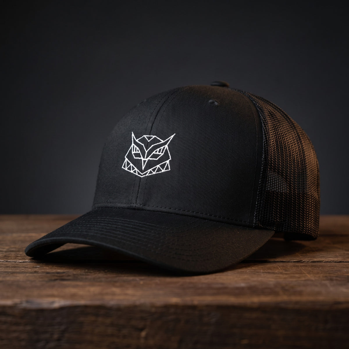 Gros plan sur la broderie hibou géométrique de la casquette trucker Hiboux Origami noire, CHT'M Boutique