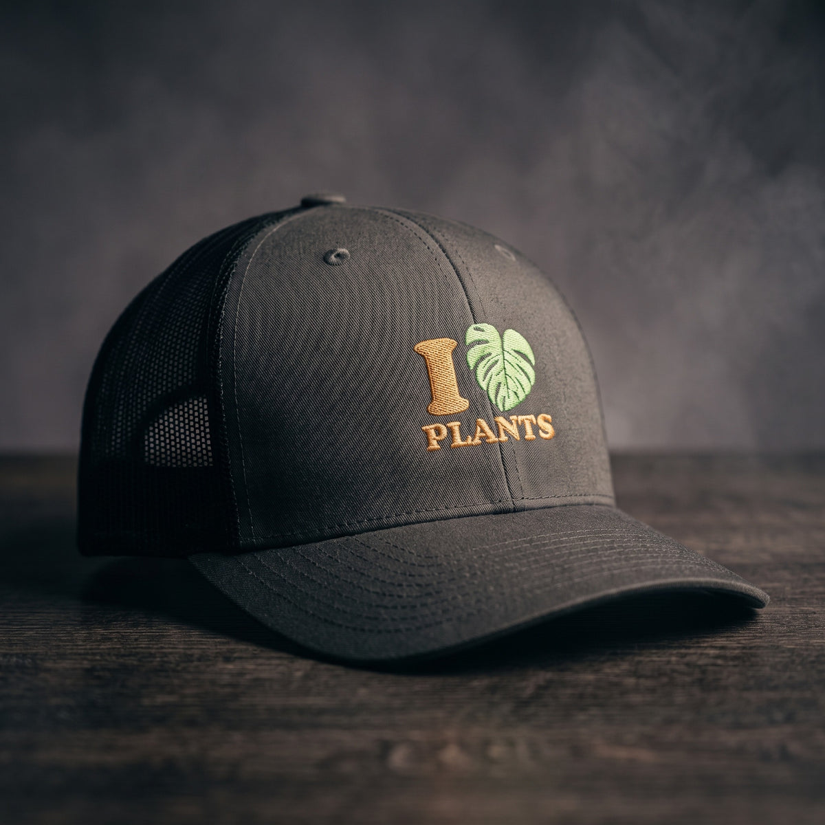 Casquette trucker anthracite et noire brodée I LOVE PLANTS avec cœur en feuille de monstera, vue trois quarts