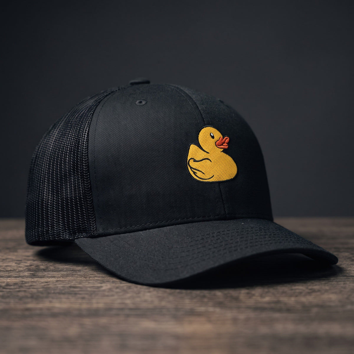 Casquette trucker brodée petit canard noire - vue de face avec logo canard jaune
