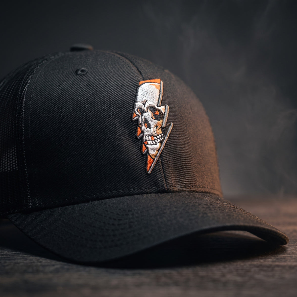 Gros plan sur le logo crâne et éclair brodé de la casquette trucker Thunder Skull noire