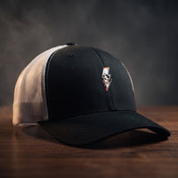 Casquette trucker Thunder Skull noire et blanche avec crâne et éclair brodés, filet blanc, posée sur bois sombre