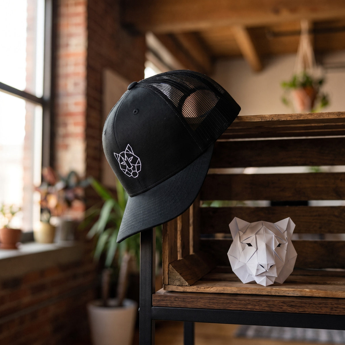 Casquette trucker TIGRE ORIGAMI noir en situation - ambiance loft urbain avec sculpture origami tigre - CHT'M Boutique