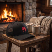 Casquette trucker TOGETHER posée près d'une cheminée cosy avec chocolat chaud, ambiance chaleureuse