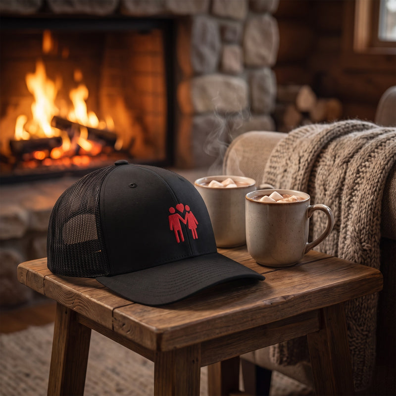 Casquette trucker TOGETHER posée près d'une cheminée cosy avec chocolat chaud, ambiance chaleureuse