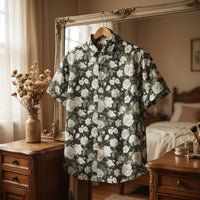 Chemise homme à manches courtes noire à pivoines blanches suspendue sur un cintre, au cadre d'un miroir ancien au-dessus d'une coiffeuse vintage - CHT'M Boutique