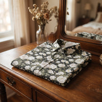 Chemise homme à manches courtes noire à pivoines blanches pliée sur une coiffeuse vintage avec vase de fleurs séchées - CHT'M Boutique