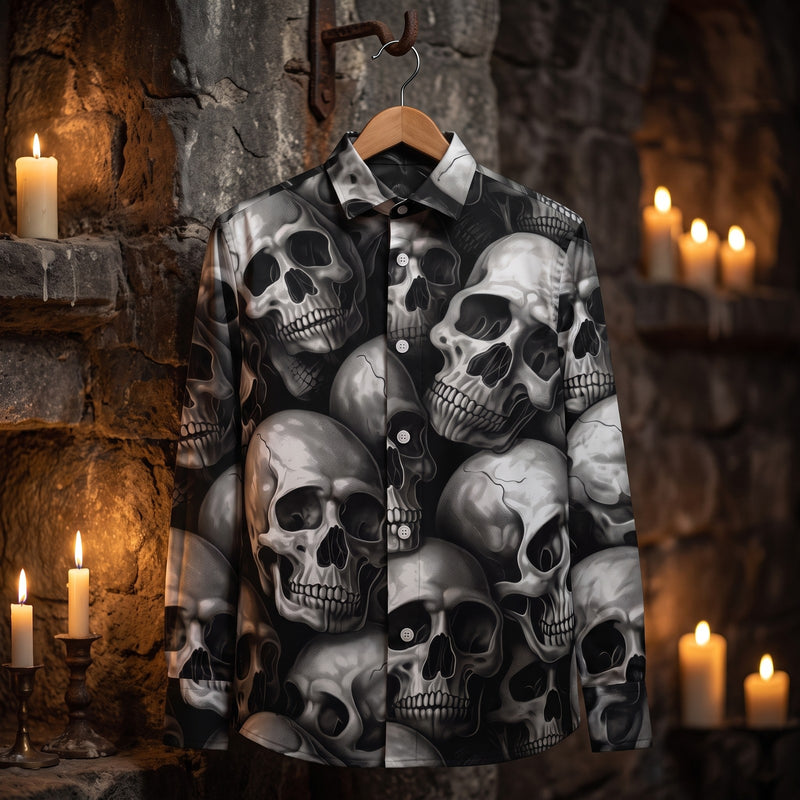 Chemise homme à manches longues noire et grise à têtes de mort suspendue sur un cintre, à un crochet en fer sur un mur de pierre sombre d'une crypte éclairée aux bougies - CHT'M Boutique