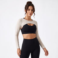 Femme portant le boléro de sport original beige sur brassière noire, photo studio