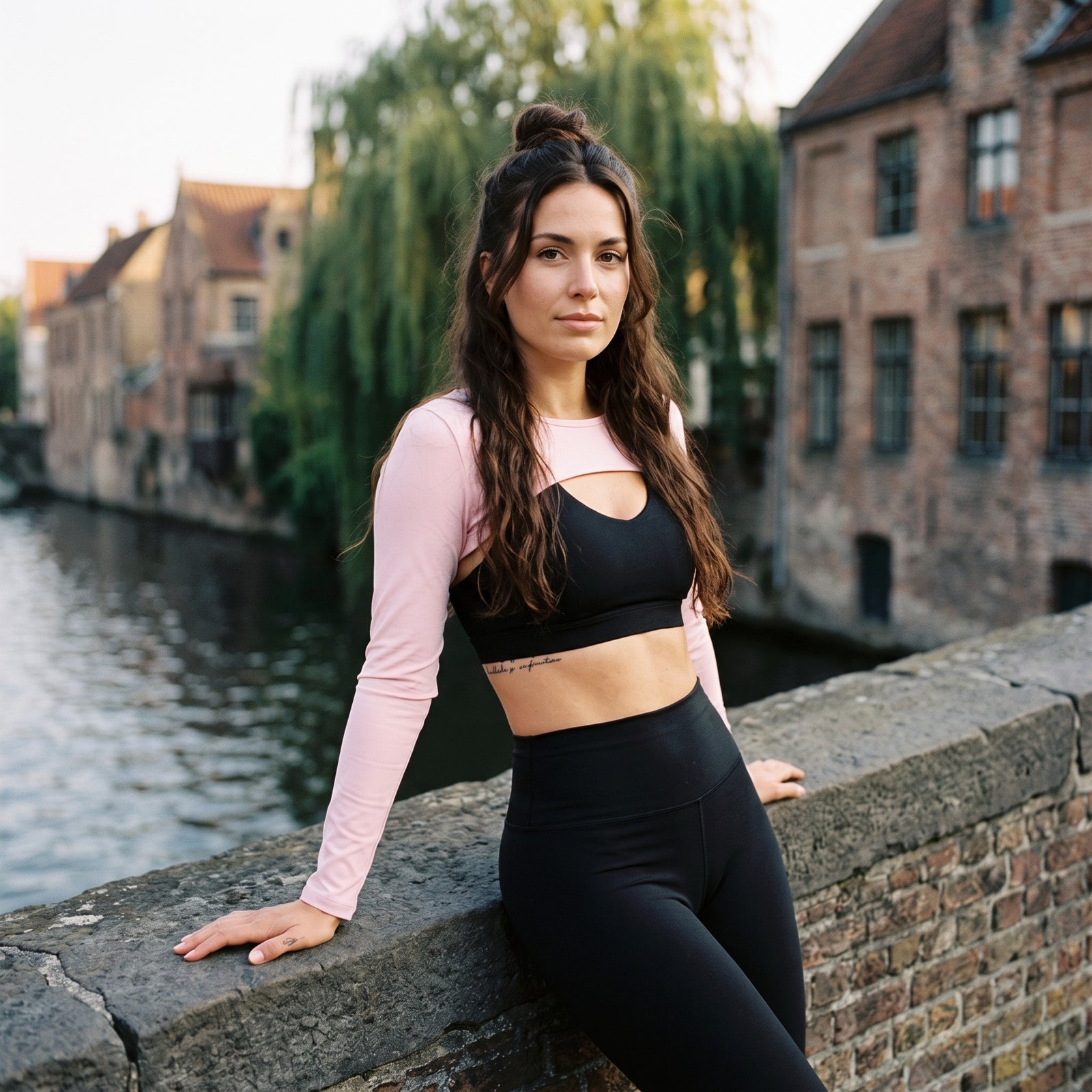 Shrug yoga femme rose clair porté sur un pont à Bruges