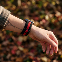 Bracelet Apple Watch élastique tissé à motifs noir et rouge porté au poignet, vue de côté | CHT'M Boutique