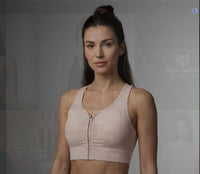 Femme portant la brassière de sport zippée crop originale CHT'M en studio, coloris rose