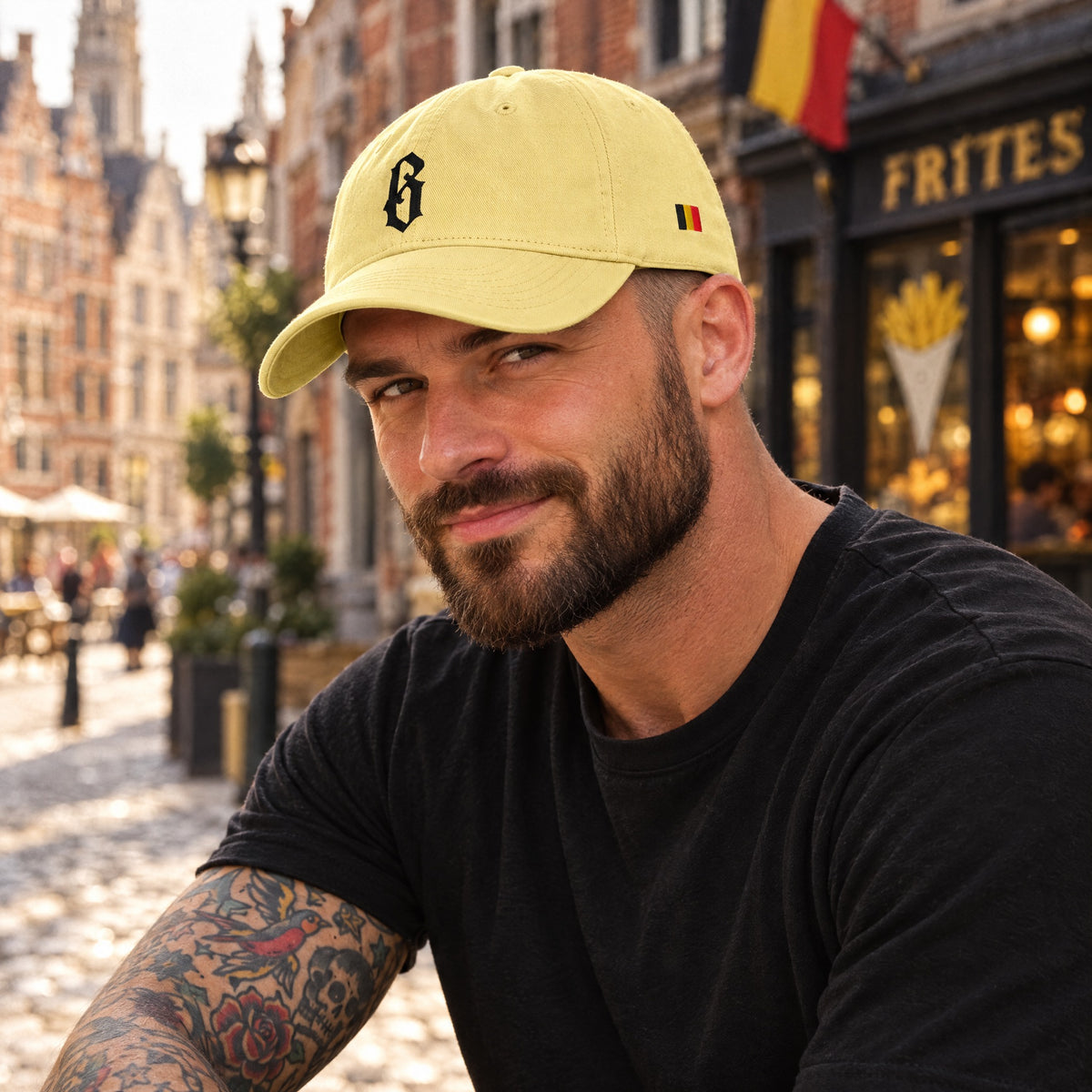 Casquette belge originale B gothique jaune portée par un homme dans une rue de Bruxelles